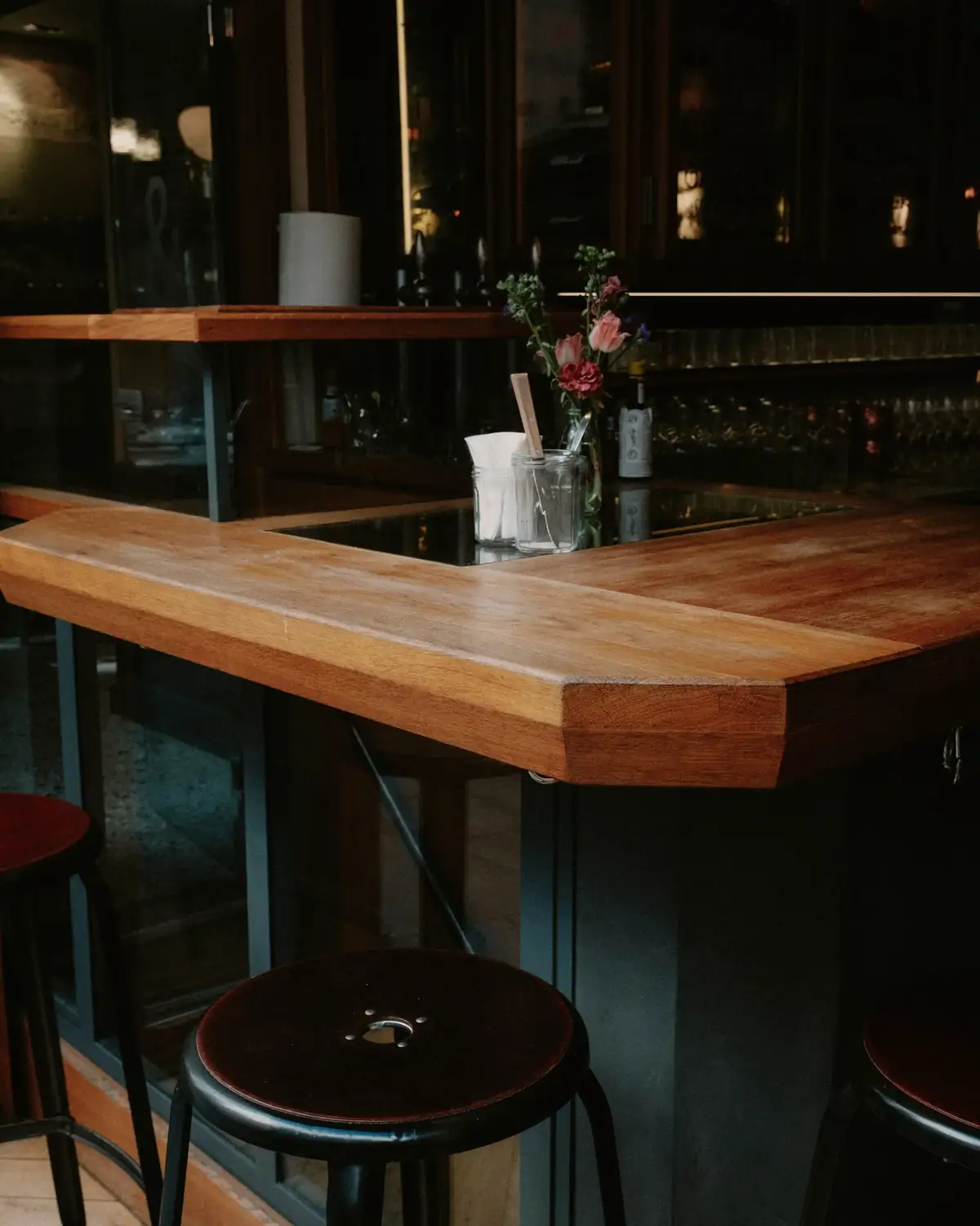 De houten bar met krukken, 's avonds met de lampen aan